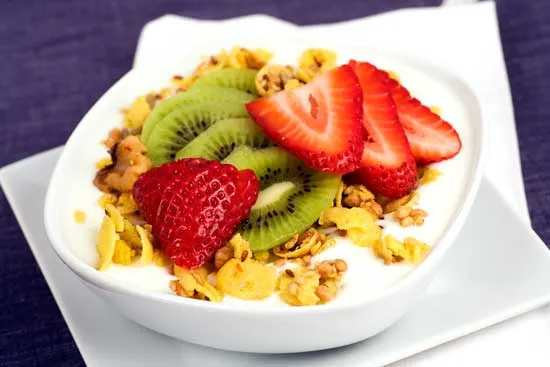 Bowl of yogurt with granola, strawberries and kiwi