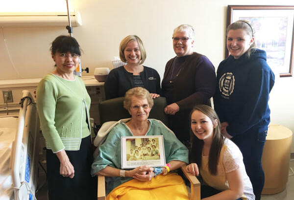 elderly lady seated with friends around her