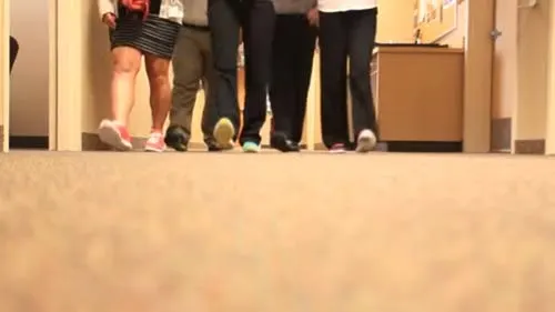Legs of people standing and walking in a hospital corridor
