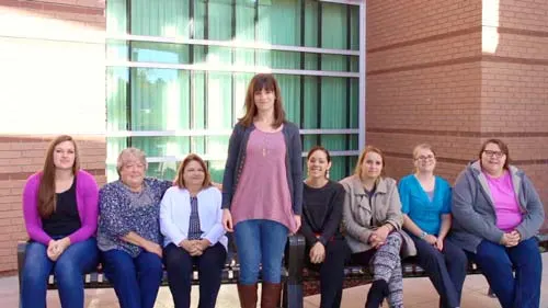 Group of Madisonhealth staff seated on a wall outside the hospital
