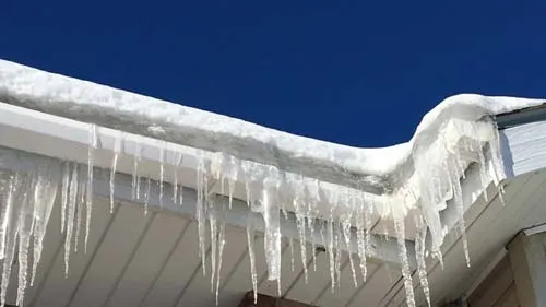 Icicles hanging from a snow-covered roof edge