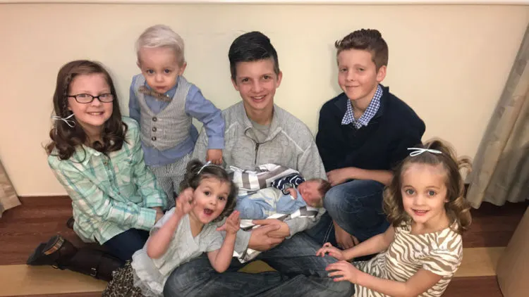 Five children posed together on a staircase