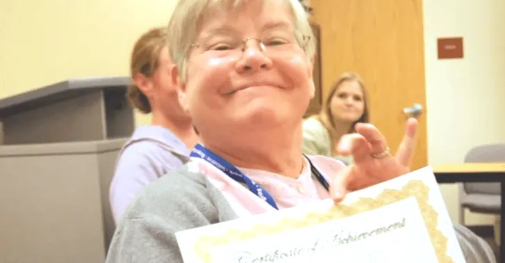 Madisonhealth staff member holding up a certificate of achievement