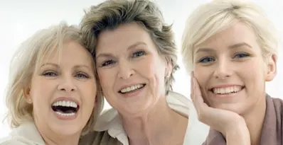 Three women of different generations laughing together