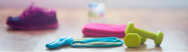 Child's trainers beside skipping ropes and small dumbbells