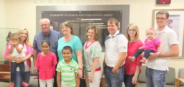 Family group posed in front of a hospital plaque