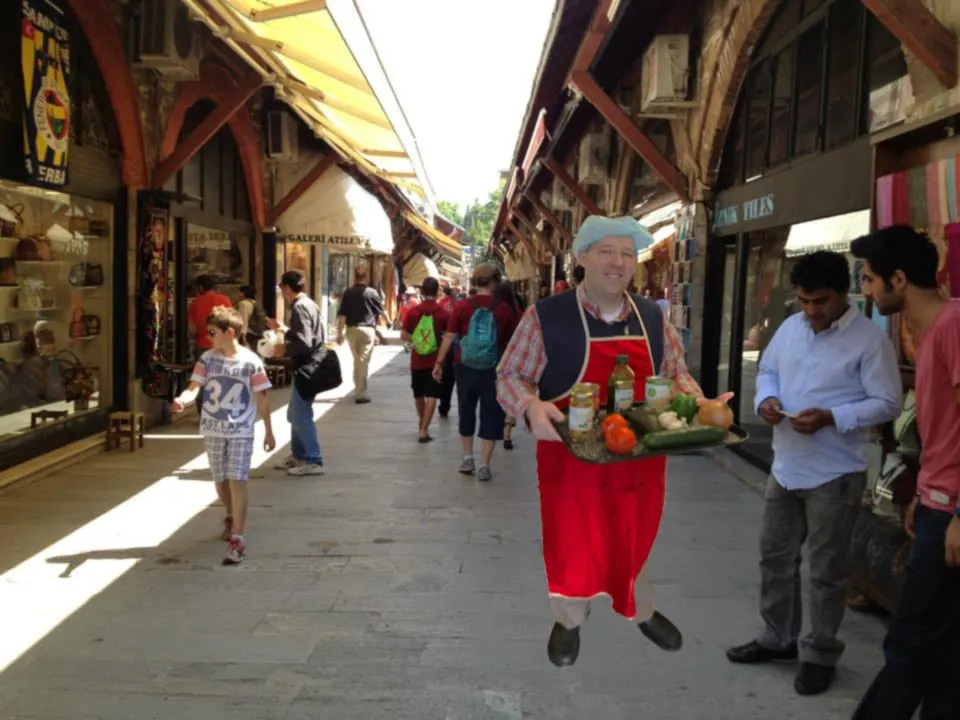 Vendor carrying a tray of goods through a covered bazaar