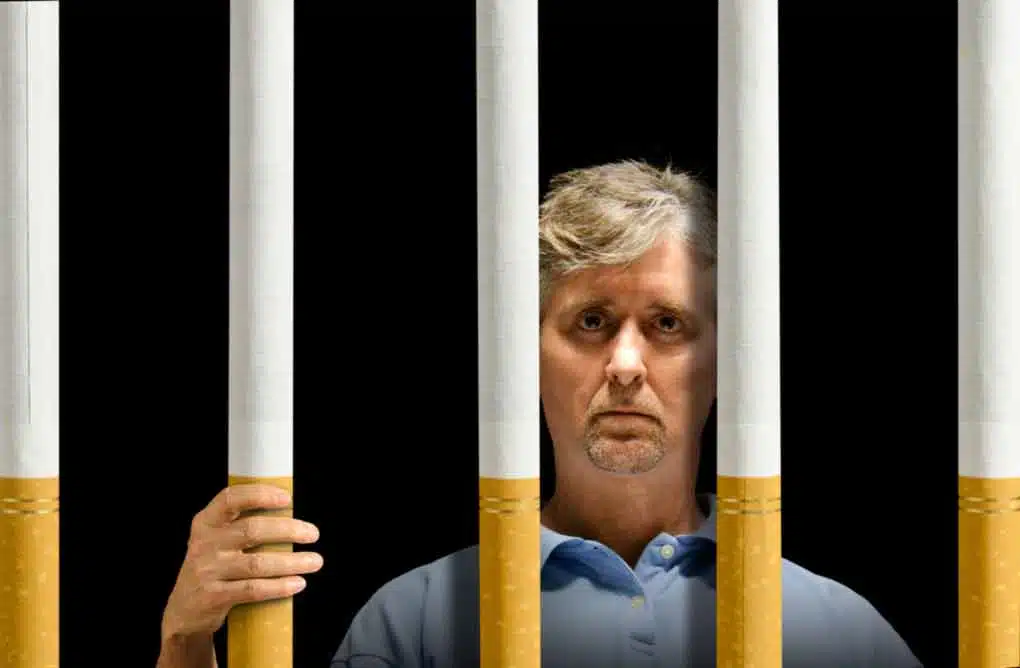 Man standing behind bars made of cigarettes
