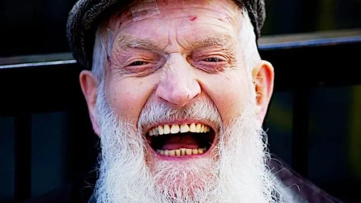 Older man with a long white beard laughing