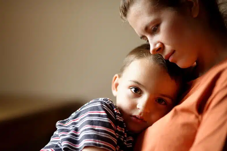 Mother holding her young son close