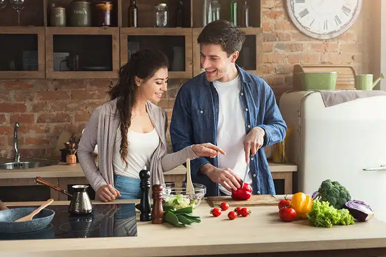 Couple preparing fresh vegetables together in a kitchen
