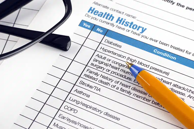 Health history questionnaire on a clipboard with a pen and stethoscope