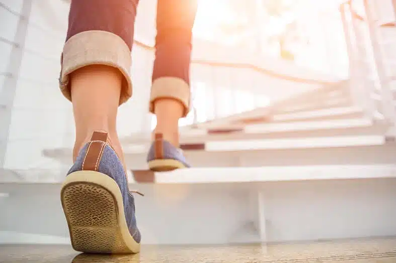 Close-up of a person's feet climbing a staircase