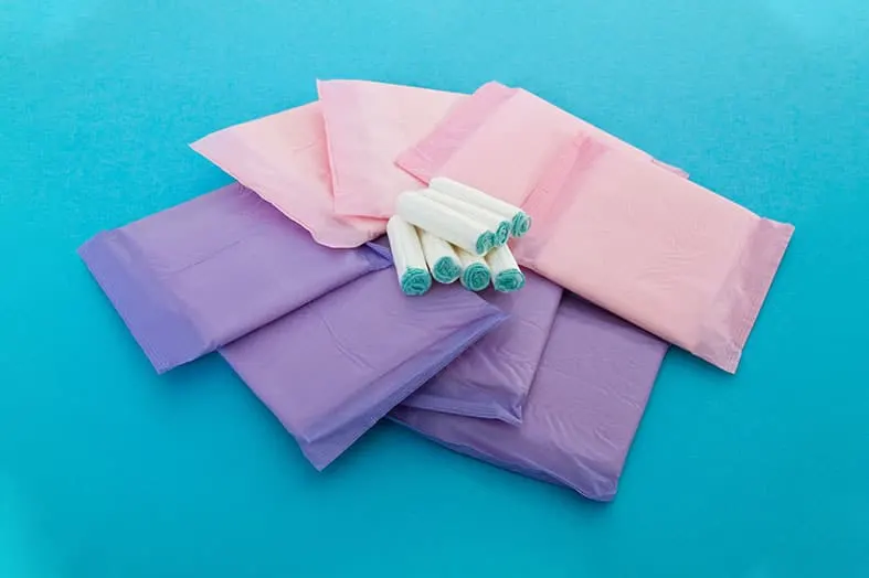 Sanitary pads and tampons arranged on a blue background