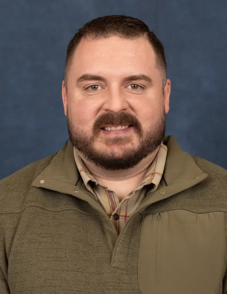 Madisonhealth staff portrait: bearded man in an olive quarter-zip pullover
