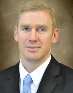 Madisonhealth staff portrait: man in a black suit and light blue tie