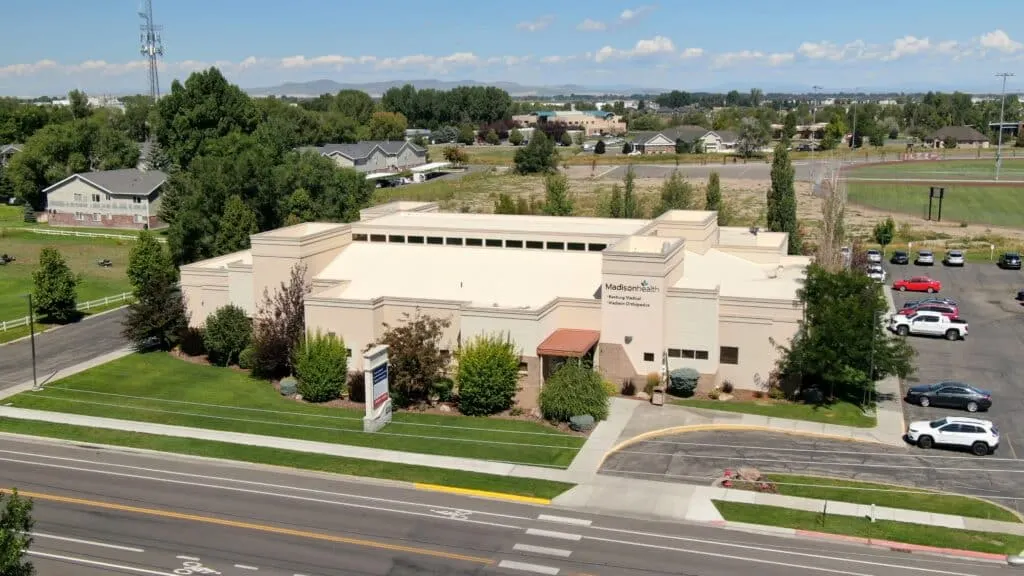 Aerial view of a single-story Madisonhealth clinic building beside a main road