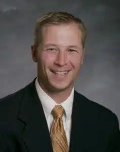 Madisonhealth staff portrait: man in a dark green blazer and gold tie