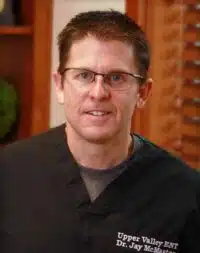 Upper Valley ENT physician in black scrubs and glasses