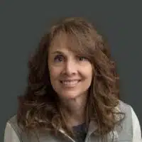Madisonhealth staff portrait: woman with curly brown hair in a grey-green top