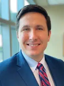 Madisonhealth staff portrait: man in a blue suit with a red striped tie