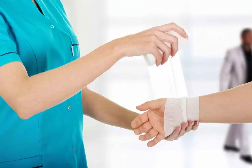 Nurse wrapping a bandage around a patient's wrist