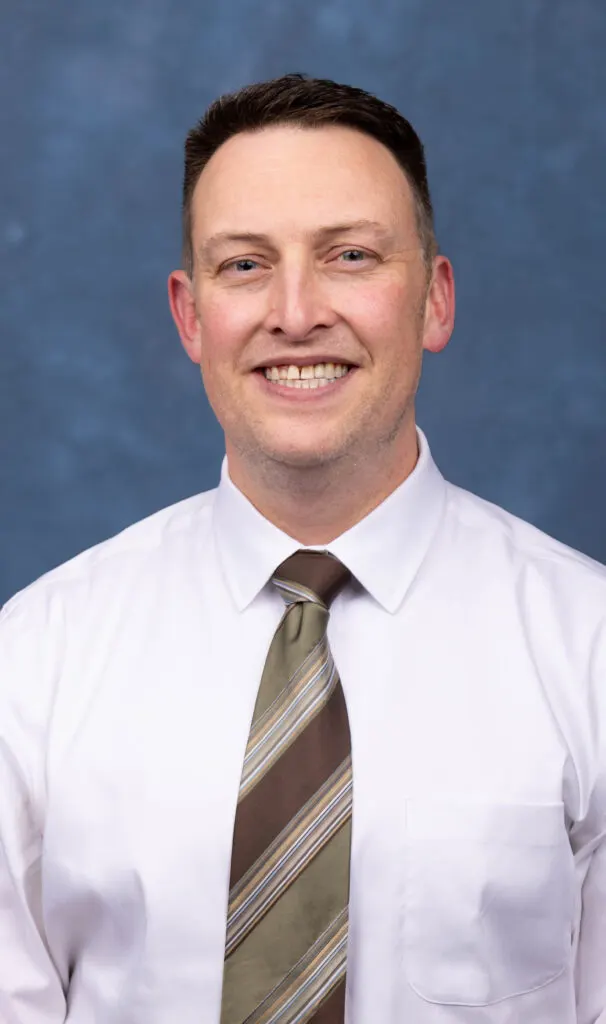 Madisonhealth staff portrait: man in a white shirt and olive striped tie