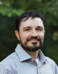 Madisonhealth staff portrait: bearded man in a light checked shirt outdoors