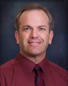 Madisonhealth staff portrait: man in a maroon shirt and navy tie