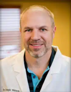 Madisonhealth physician portrait: man in a white coat against a gold background