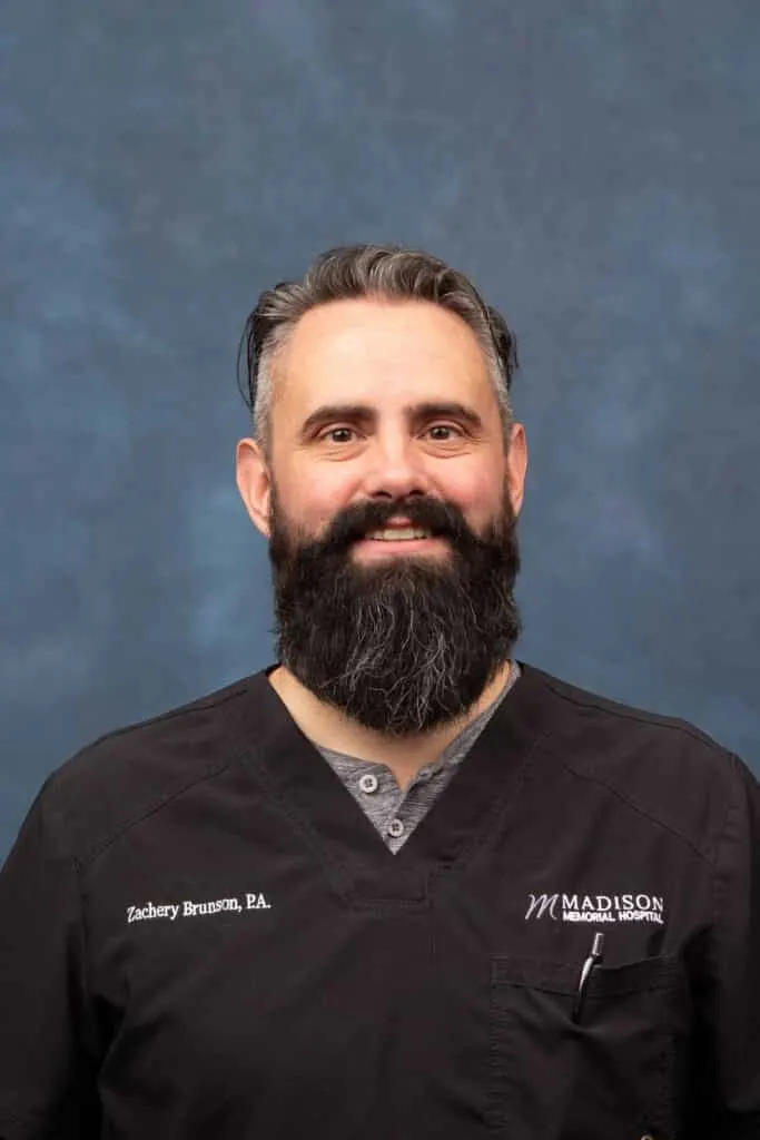 Madisonhealth staff portrait: bearded man in black Madison Memorial Hospital scrubs