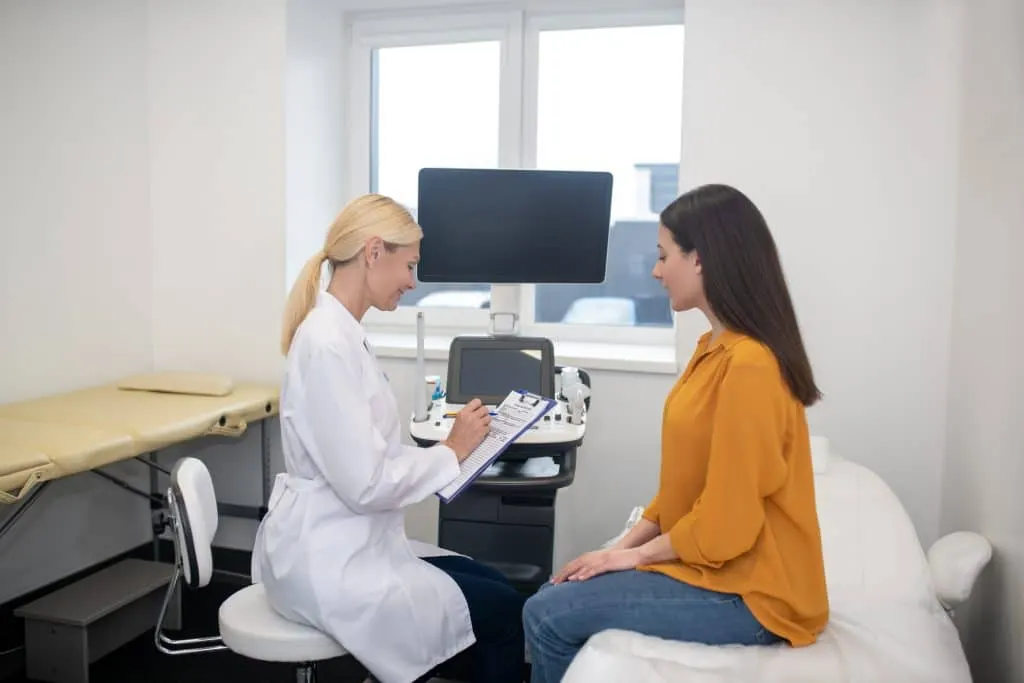 Clinician performing an ultrasound consultation with a patient in an exam room