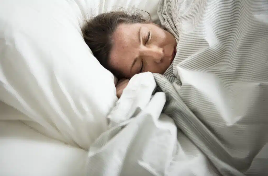 Woman sleeping peacefully on her side in bed