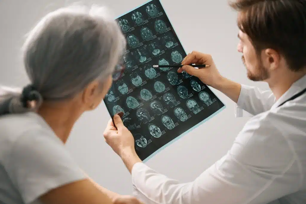 Two clinicians reviewing a sheet of brain MRI images together