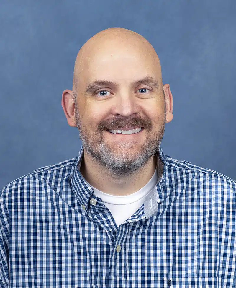 Pediatric nurse practitioner and psychiatric mental health nurse practitioner portrait on blue backdrop