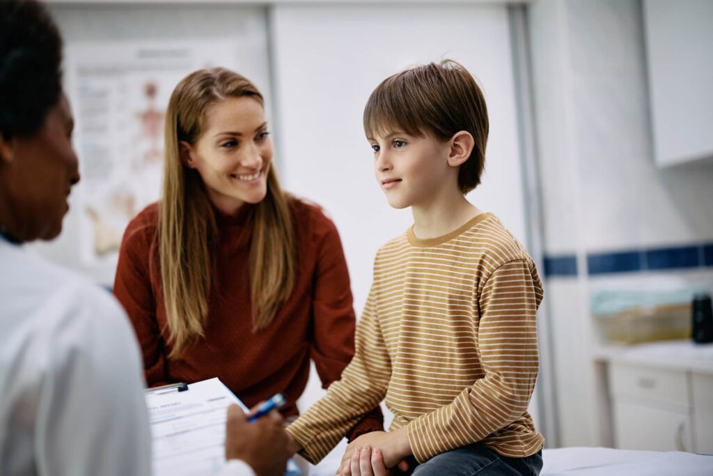 Healthcare professional conducting autism screening with a child, while a parent observes
