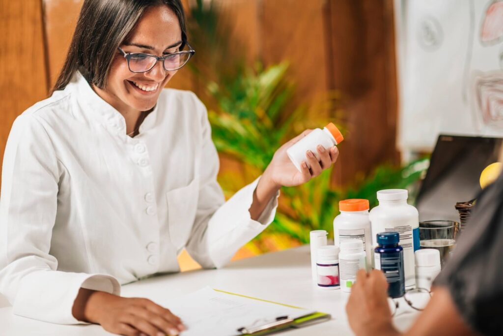 Doctor discussing medication management with bottles on the desk.