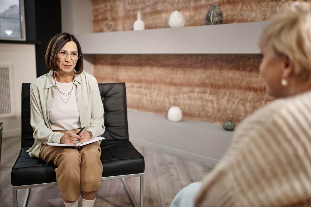 A female therapist attentively listening to a patient during a one-on-one crisis therapy session.