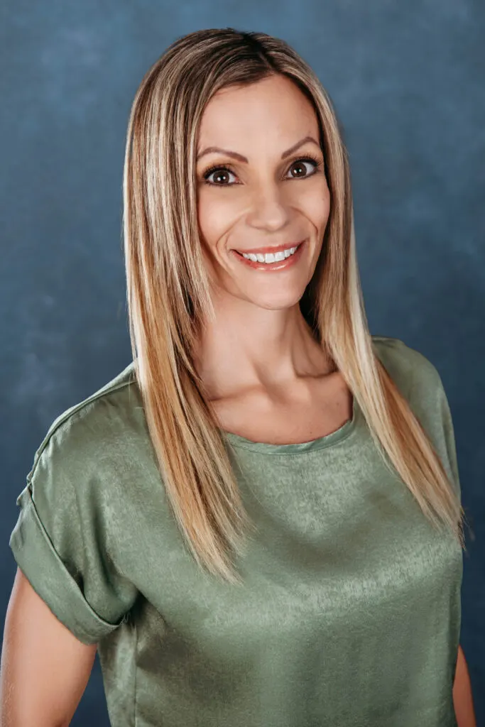 Madisonhealth staff portrait: woman with long blonde hair in a green satin top