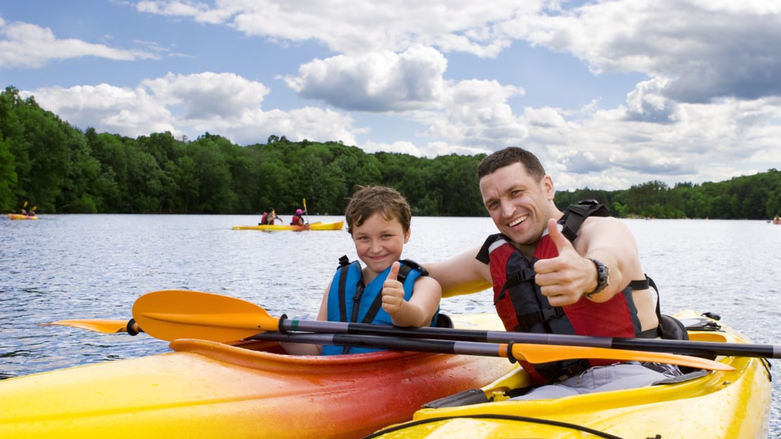 Father and Son in water enjoying kayaking