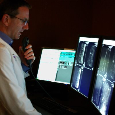 radiologist viewing scans, reporting his findings