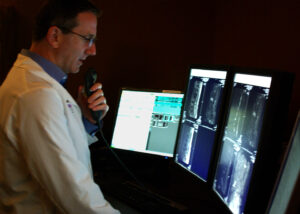 radiologist viewing scans, reporting his findings